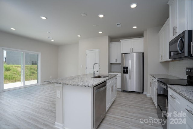 kitchen featuring a center island with sink, white cabinetry, sink, and stainless steel appliances