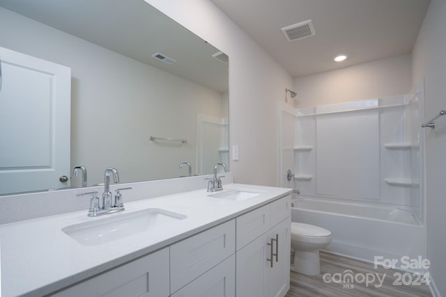 full bathroom featuring shower / bathtub combination, hardwood / wood-style flooring, vanity, and toilet