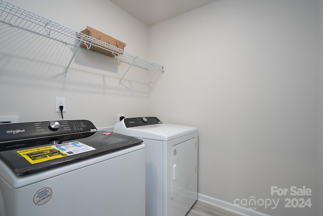 washroom with light hardwood / wood-style floors and separate washer and dryer