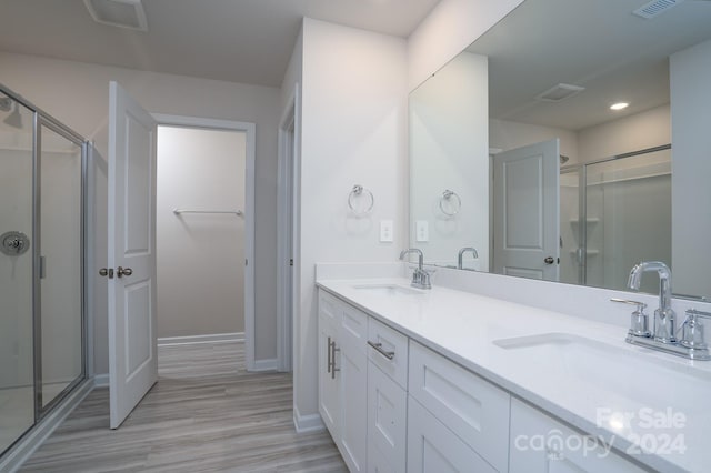 bathroom with vanity, hardwood / wood-style floors, and an enclosed shower