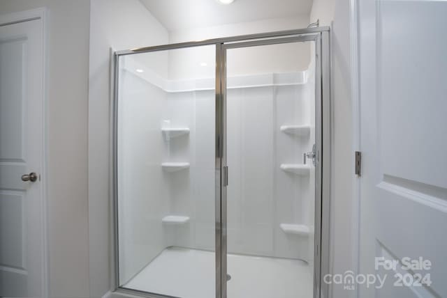 bathroom featuring a shower with shower door