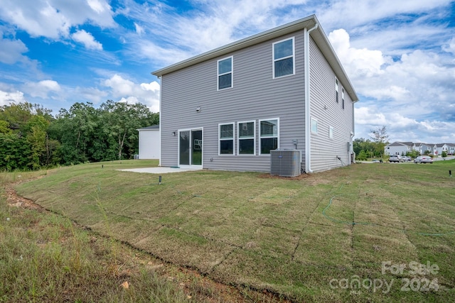 rear view of property featuring a lawn, a patio area, and central AC