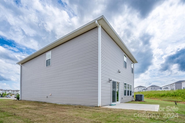 view of home's exterior featuring a lawn, a patio, and central air condition unit