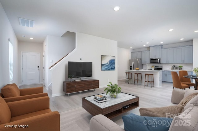 living room featuring light hardwood / wood-style floors and sink