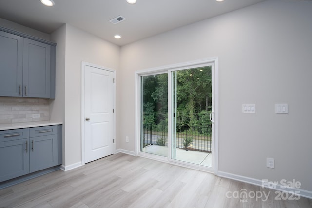 interior space with decorative backsplash, plenty of natural light, and light wood-type flooring