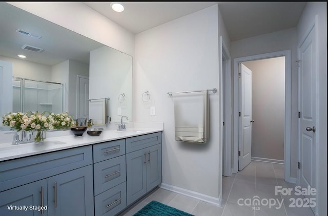 bathroom featuring a shower with door, vanity, and tile patterned floors