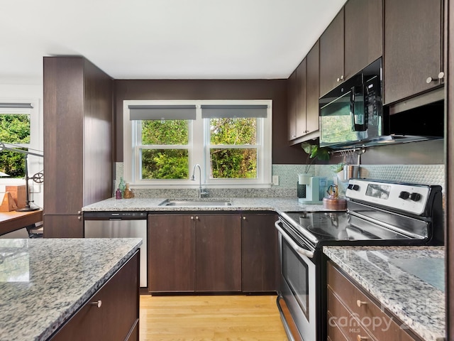 kitchen featuring appliances with stainless steel finishes, light hardwood / wood-style flooring, a healthy amount of sunlight, and sink