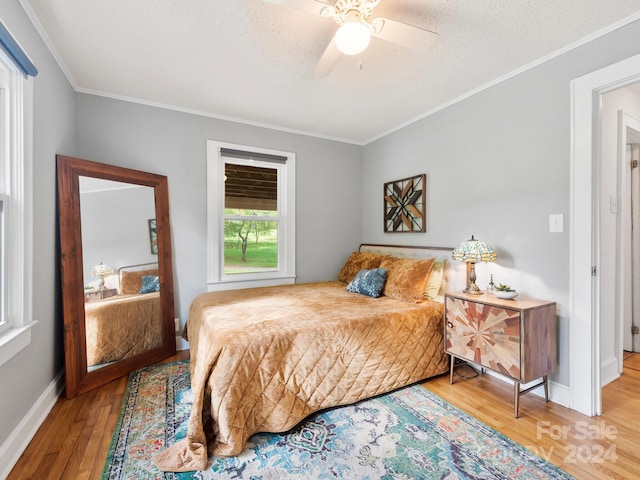 bedroom featuring crown molding, a textured ceiling, hardwood / wood-style flooring, and ceiling fan