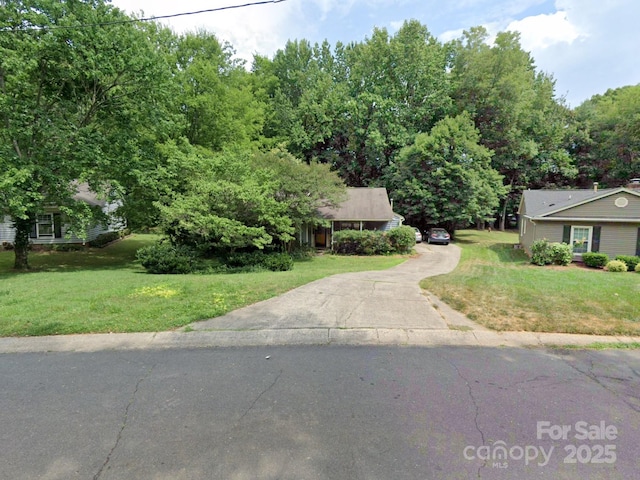 view of front of home with driveway and a front lawn