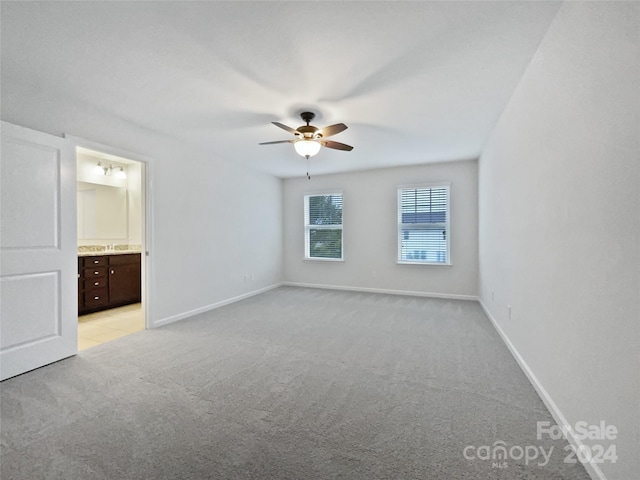 spare room featuring ceiling fan and light carpet