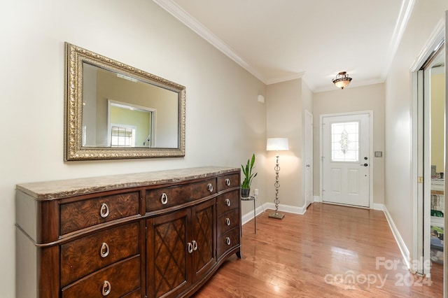 foyer with crown molding and light hardwood / wood-style floors