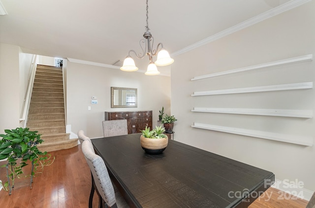 dining area featuring hardwood / wood-style flooring, crown molding, and a chandelier