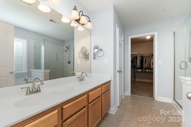 bathroom featuring vanity, tile patterned flooring, and walk in shower