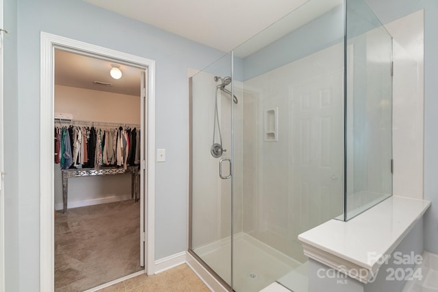 bathroom featuring a shower with shower door and tile patterned floors