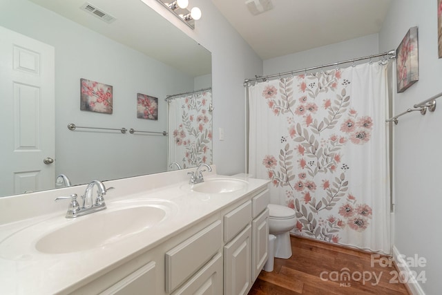 bathroom with curtained shower, hardwood / wood-style flooring, vanity, and toilet