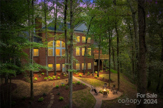 back of house featuring a balcony and an outdoor fire pit