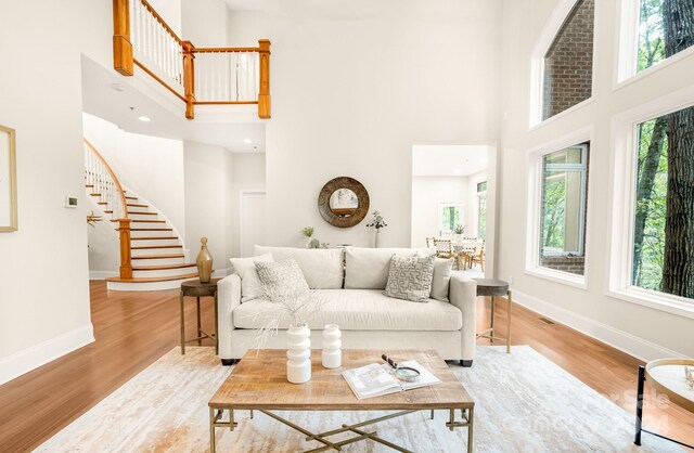 10250 Barringer Ct, Mount Pleasant, NC 28124 - living room featuring stairs, a high ceiling, wood finished floors, and baseboards