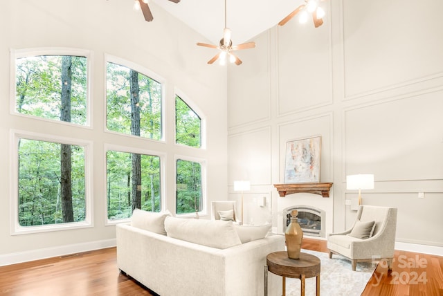 living room featuring high vaulted ceiling, light wood-type flooring, and ceiling fan