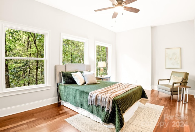 bedroom with ceiling fan, hardwood / wood-style floors, and multiple windows