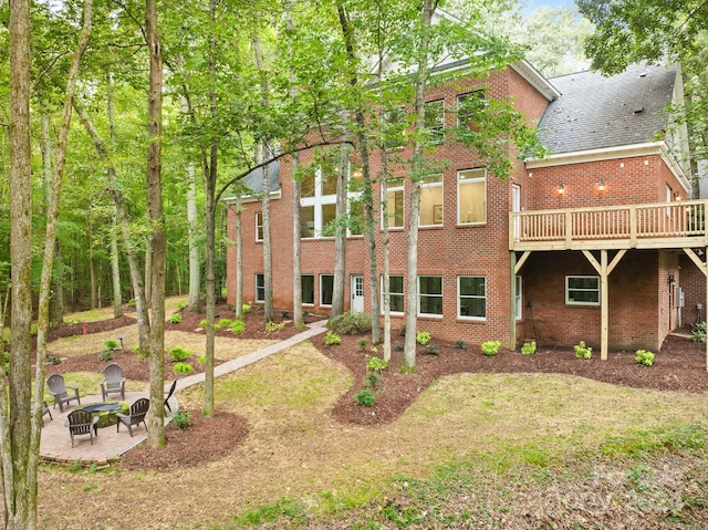 back of property featuring a wooden deck, a patio area, and a fire pit