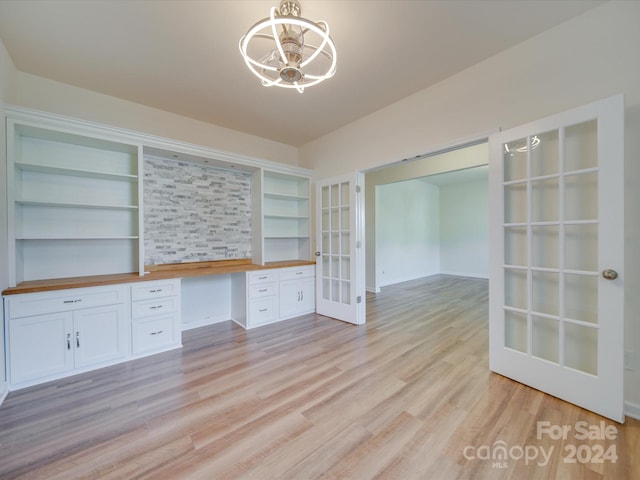 unfurnished living room with french doors, light hardwood / wood-style floors, and built in features