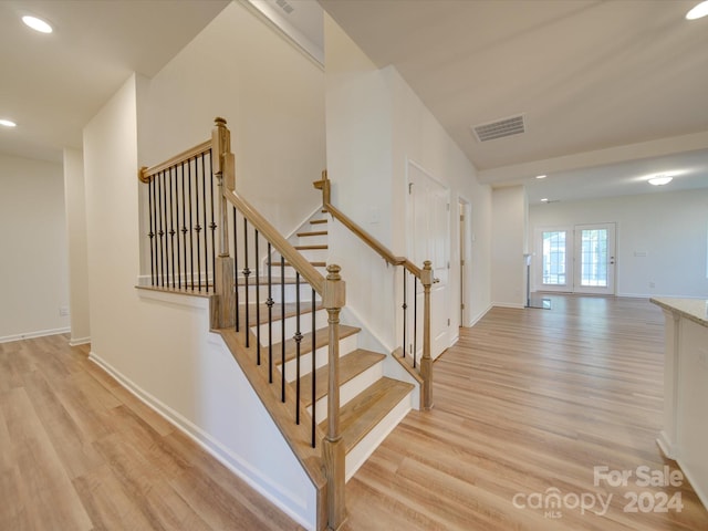 staircase featuring french doors and hardwood / wood-style floors