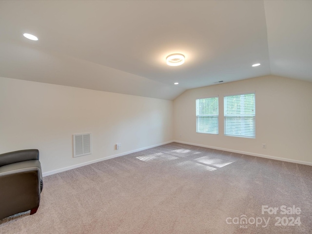 additional living space featuring light carpet and lofted ceiling