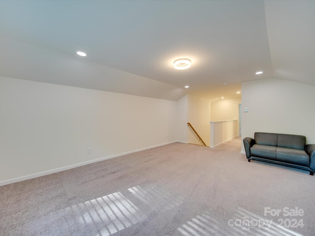 sitting room with light carpet and vaulted ceiling