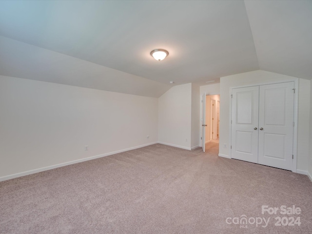 additional living space with lofted ceiling and light carpet