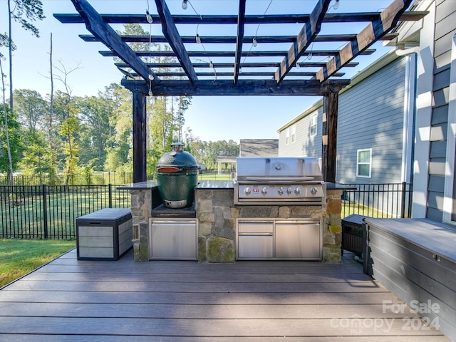 wooden terrace with a pergola, grilling area, and exterior kitchen