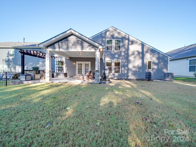 rear view of house featuring french doors, central AC unit, a pergola, a lawn, and a patio area