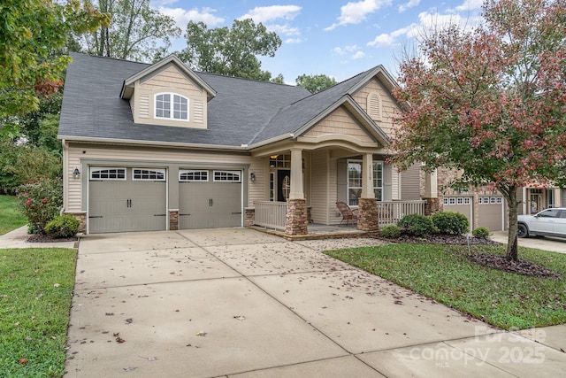 view of front facade featuring a garage, a front lawn, and a porch