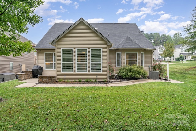 rear view of house featuring central AC and a yard