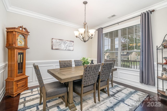 dining space featuring crown molding, dark hardwood / wood-style floors, and an inviting chandelier