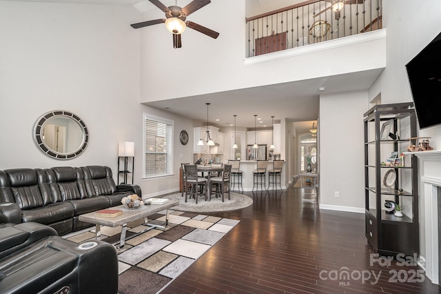 living room with ceiling fan and dark hardwood / wood-style flooring