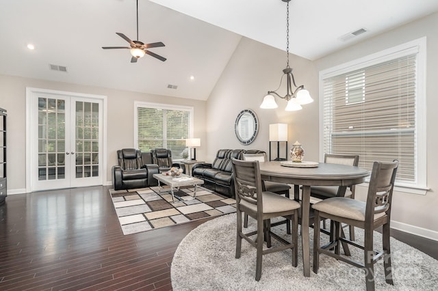 dining area featuring ceiling fan with notable chandelier, high vaulted ceiling, dark hardwood / wood-style floors, and french doors