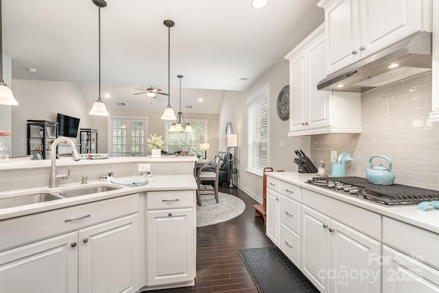 kitchen with decorative light fixtures, stainless steel gas stovetop, white cabinetry, sink, and dark wood-type flooring