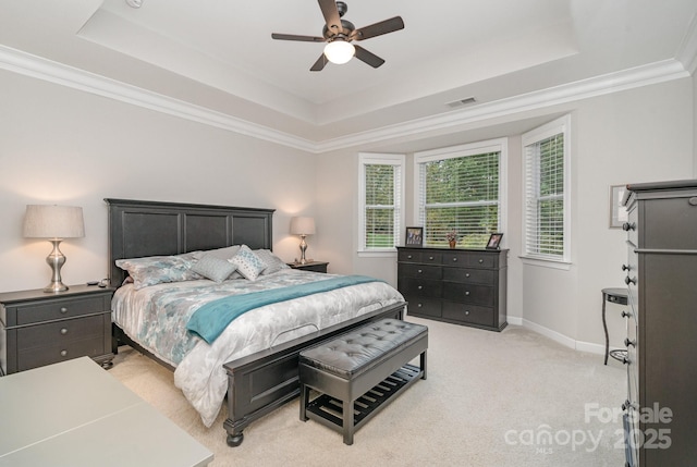 bedroom with crown molding, ceiling fan, a tray ceiling, and light carpet