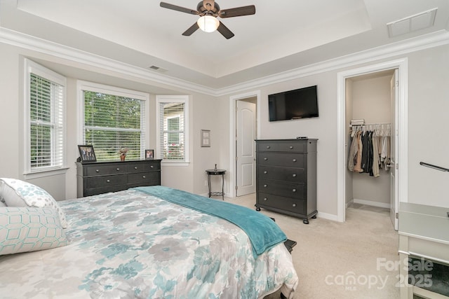 bedroom featuring crown molding, a raised ceiling, and light carpet