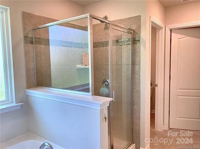 bathroom with separate shower and tub and tile patterned floors