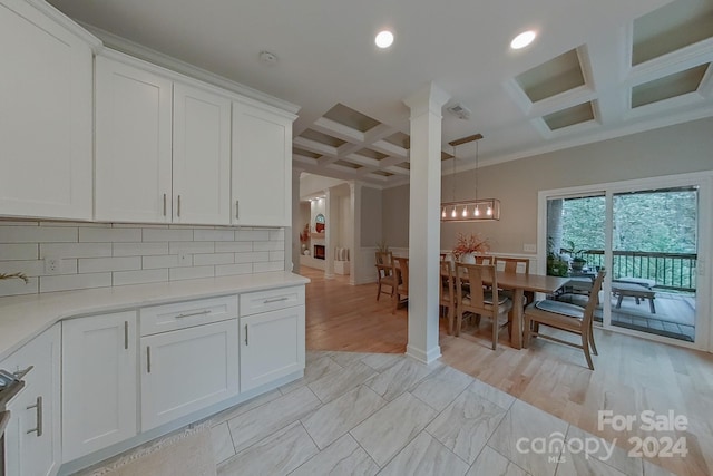 kitchen with coffered ceiling, hanging light fixtures, backsplash, and white cabinetry