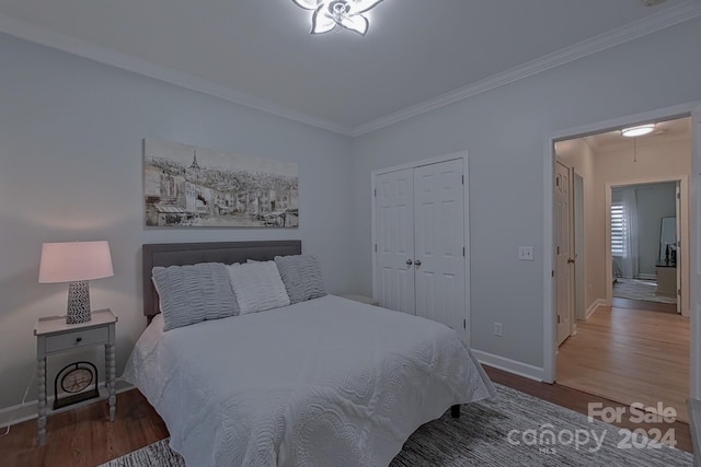 bedroom featuring a closet, crown molding, and hardwood / wood-style floors