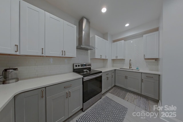 10604 Russet Pl, Charlotte, NC 28227 - kitchen with stainless steel range with electric cooktop, wall chimney exhaust hood, gray cabinets, tasteful backsplash, and light countertops