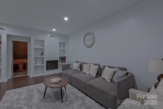 10604 Russet Pl, Charlotte, NC 28227 - living room featuring wood finished floors, built in features, recessed lighting, and a glass covered fireplace