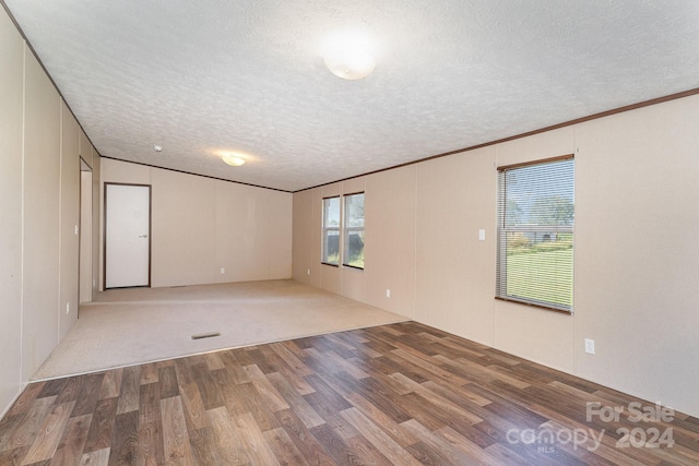 spare room with ornamental molding, a textured ceiling, and hardwood / wood-style floors