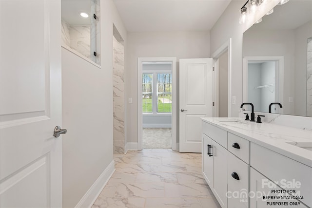 full bathroom featuring a walk in shower, double vanity, marble finish floor, and a sink