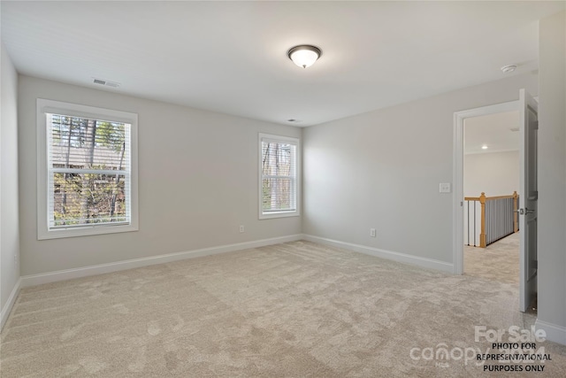 carpeted empty room with visible vents and baseboards