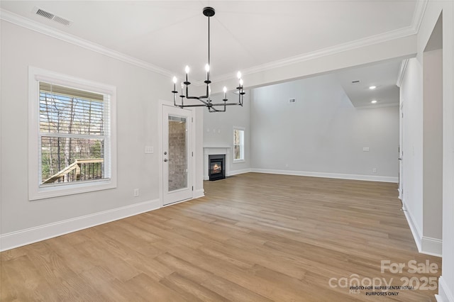 8605 Carly Ln, Mint Hill, NC 28227 - unfurnished living room featuring crown molding, a chandelier, light wood finished floors, baseboards, and a glass covered fireplace