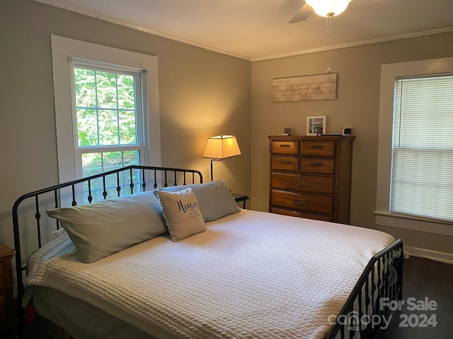 bedroom with ornamental molding, dark wood-type flooring, and ceiling fan