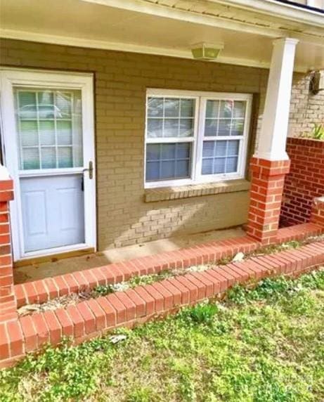 view of exterior entry with covered porch